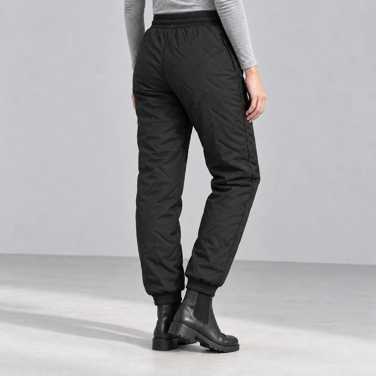 Women’s fleece-lined winter pants in black — rear studio view