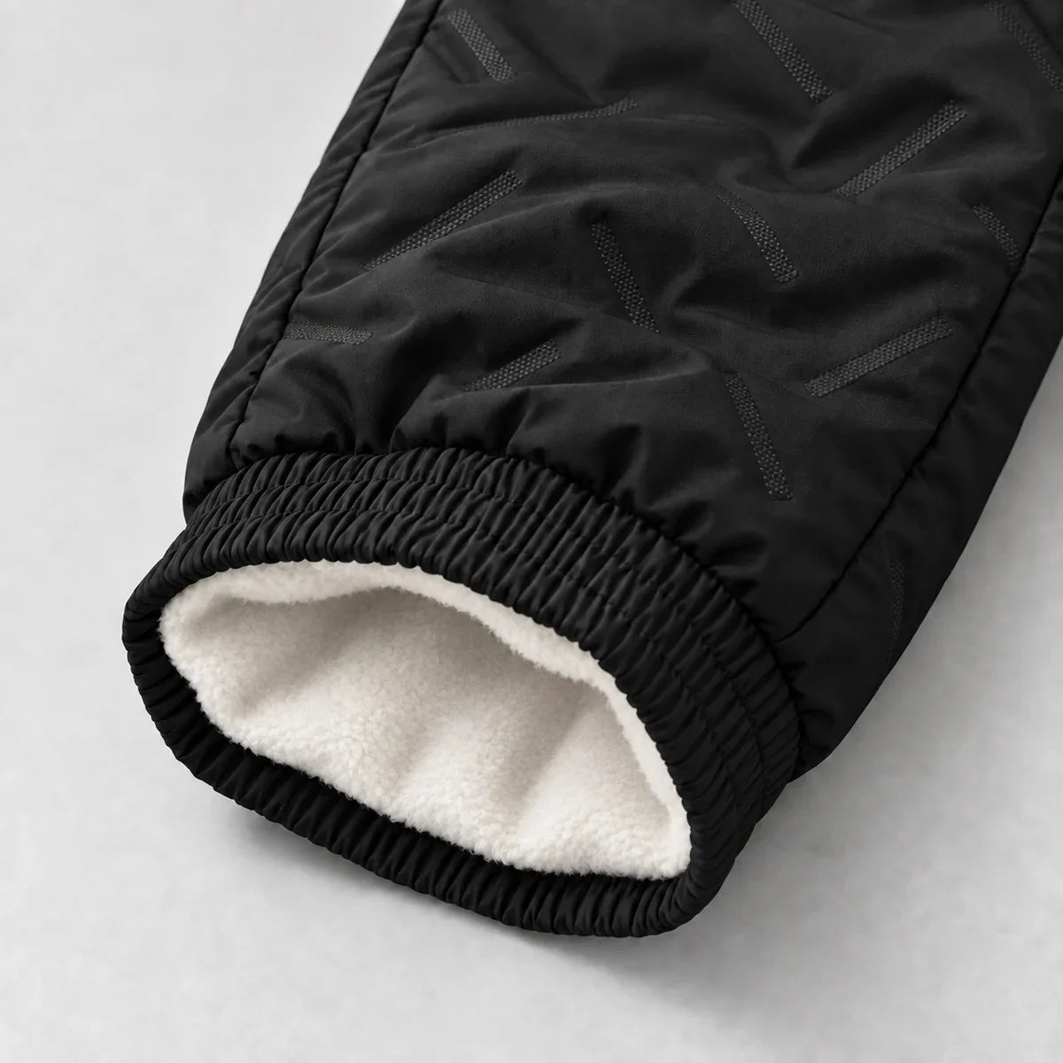 Black fleece-lined pants — ankle opening and diagonal textured fabric detail