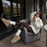 Luma black fleece-lined tights styled on a winter terrace