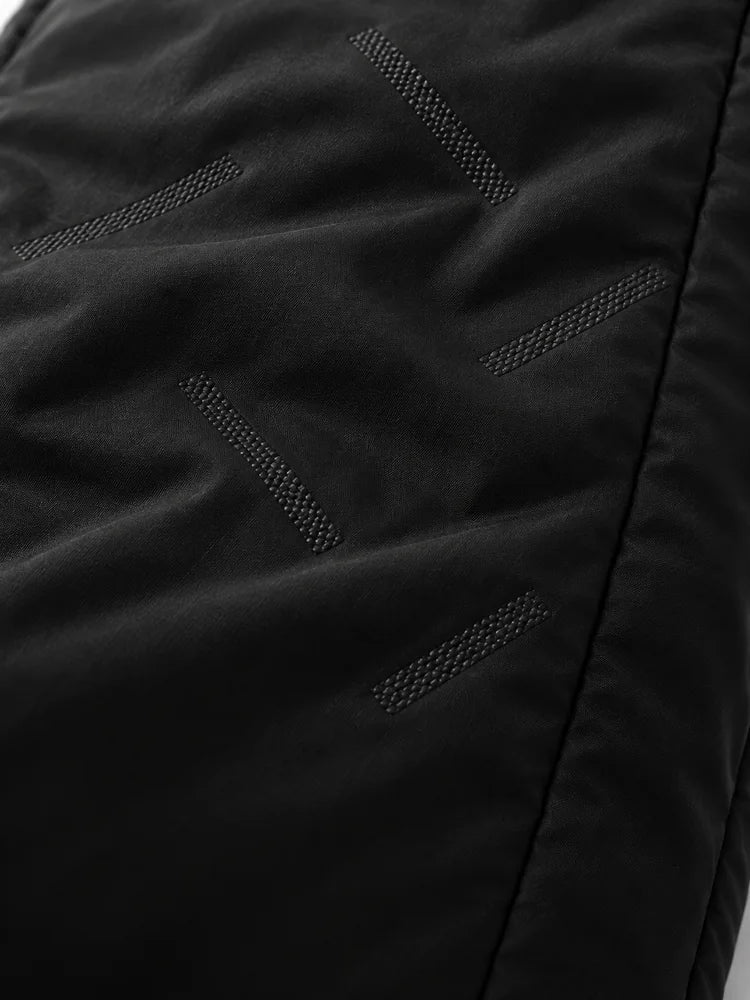Portrait close-up of the black pant outer fabric with sparse diagonal woven details