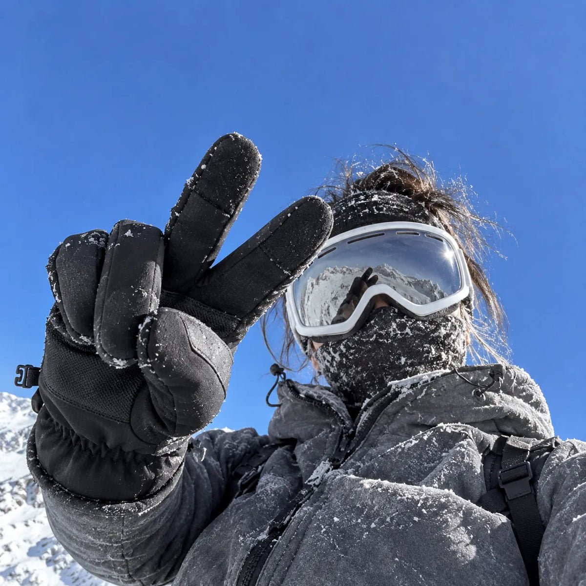 Woman wearing black winter gloves in alpine snow