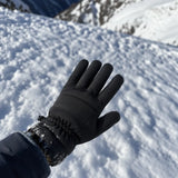 Black glove held above snowy trail