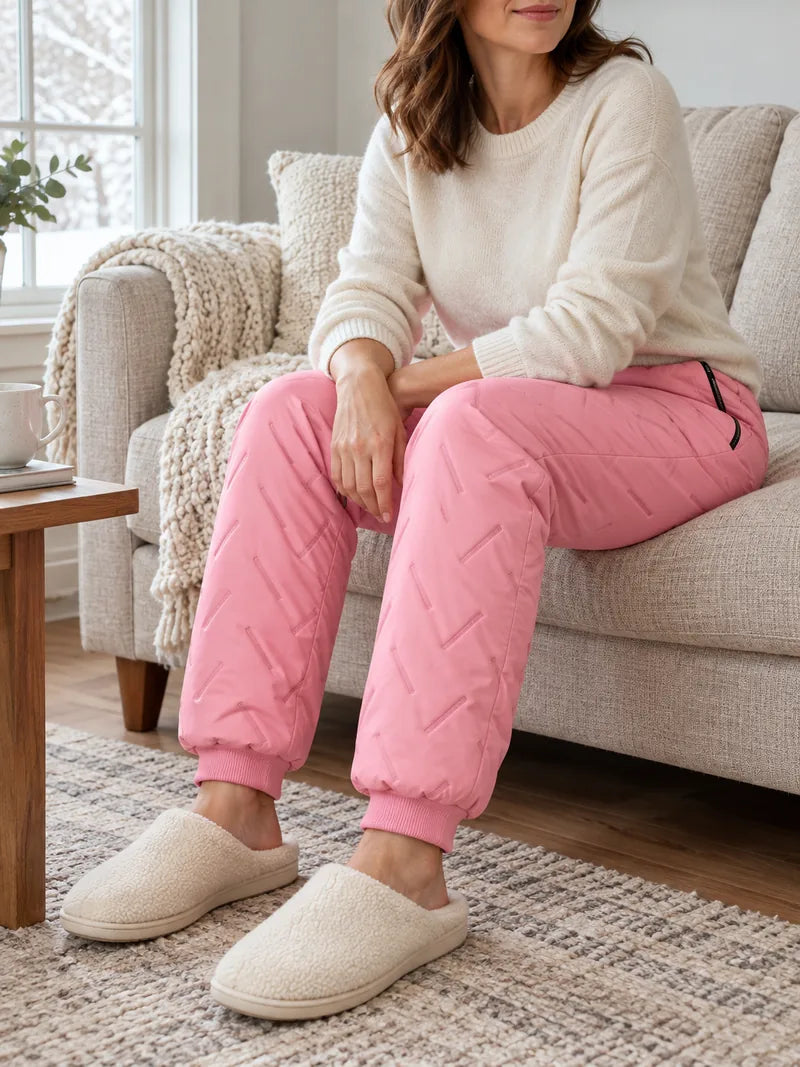 Pink fleece-lined pants styled with a knit and slippers at home